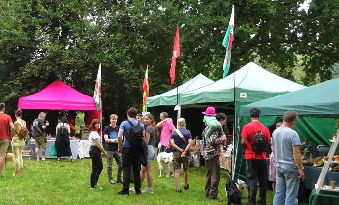 Colourful stalls selling local produce with people shopping.